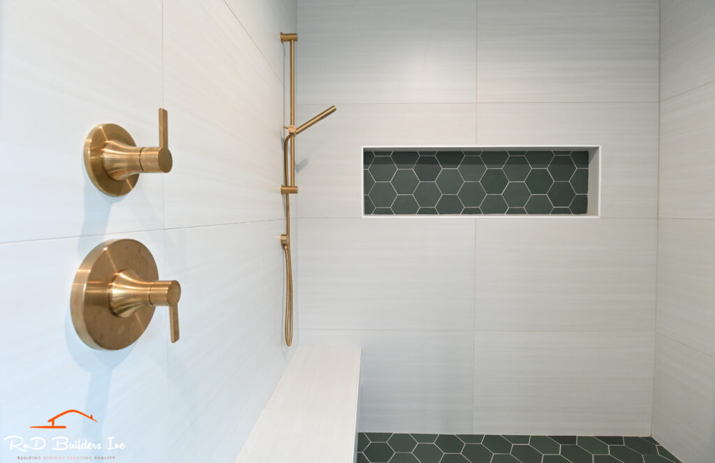Walk-in Shower with Brushed Gold Fixtures in Newbury Park Newbury Park home remodel: Walk-in shower with brushed gold fixtures, white large-format tile, and dark green hexagon tile niche in Newbury Park by RnD Builders Inc