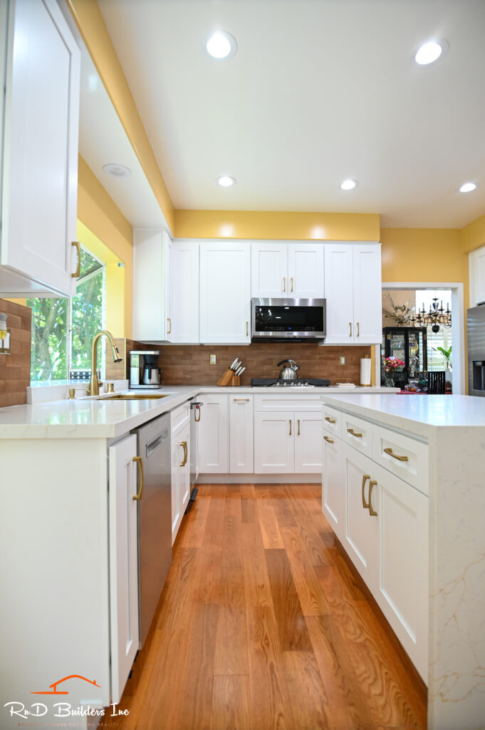 Manhattan Beach kitchen remodel: Bright kitchen remodel with white shaker cabinets, quartz countertops, and warm wood flooring in Manhattan Beach by RnD Builders Inc
