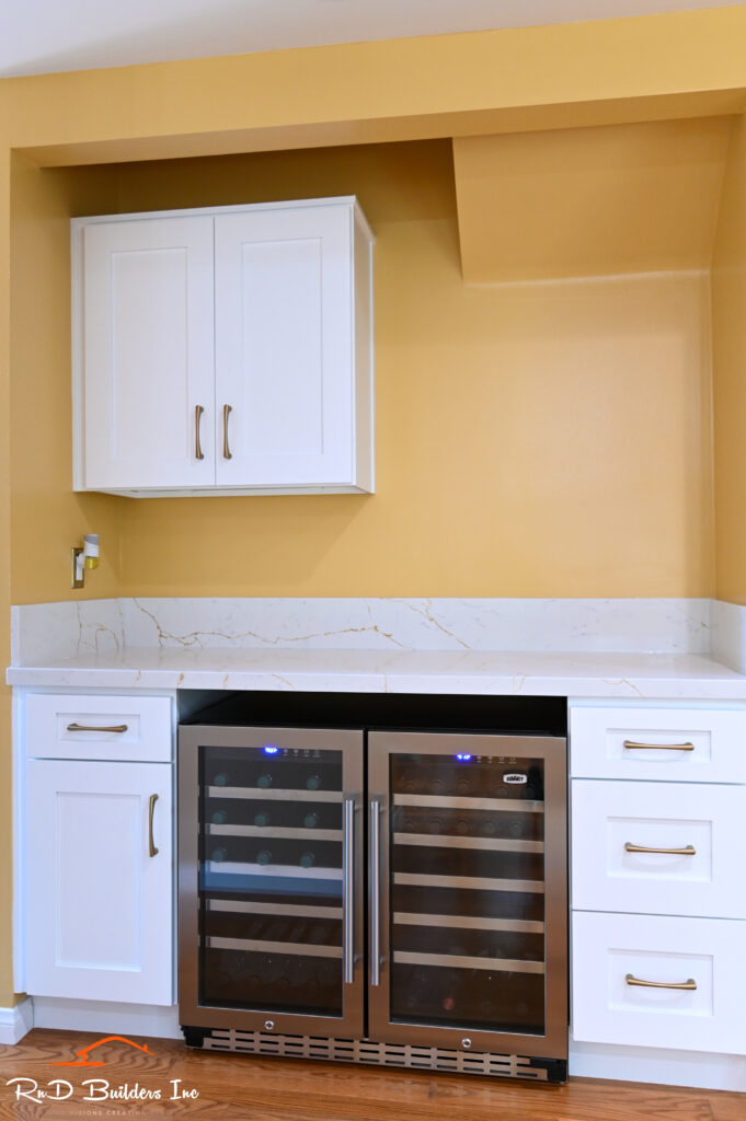 Manhattan Beach kitchen remodel: Built-in wet bar niche with white shaker cabinets, quartz countertop, and dual-zone wine cooler in Manhattan Beach by RnD Builders Inc