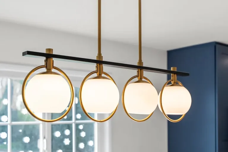 Thousand Oaks home transformation: Four-globe brass and matte black linear pendant light fixture with opal glass shades in Thousand Oaks by RnD Builders Inc
