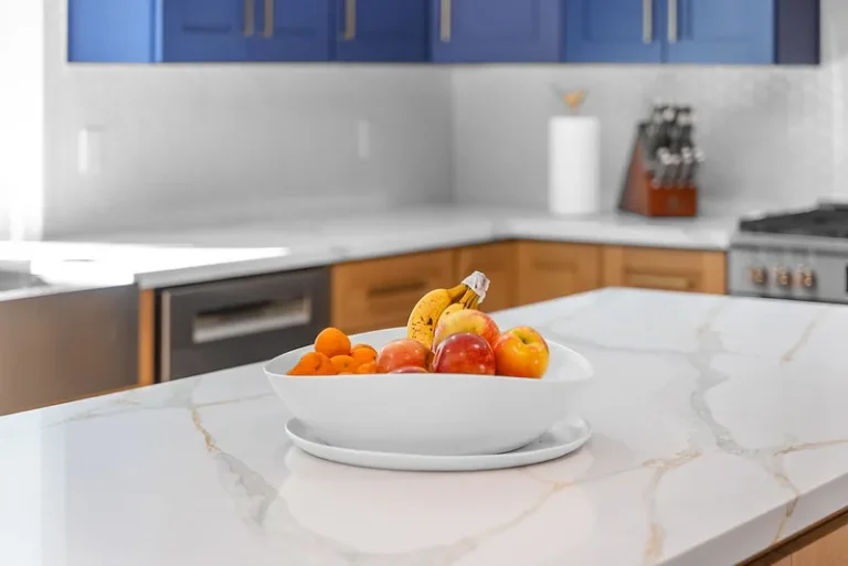 Thousand Oaks home transformation: Modern kitchen with blue upper cabinets, quartz island countertop, and fruit bowl in Thousand Oaks by RnD Builders Inc