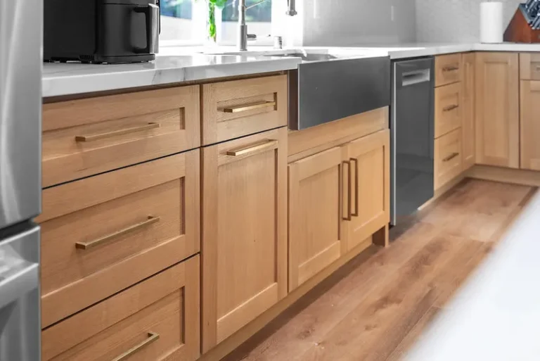 Light wood shaker kitchen cabinets with brass hardware and stainless farmhouse sink in Thousand Oaks by RnD Builders Inc