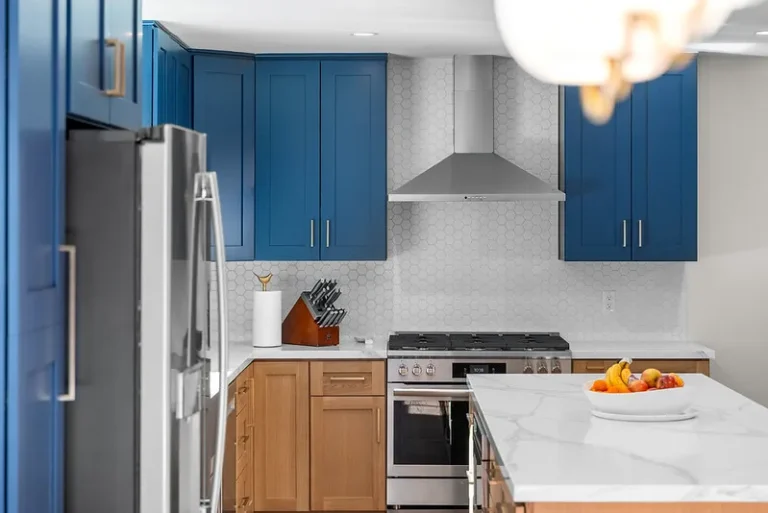 Thousand Oaks home transformation: Two-tone kitchen with navy blue upper cabinets, natural wood lower cabinets, and stainless steel appliances in Thousand Oaks by RnD Builders Inc
