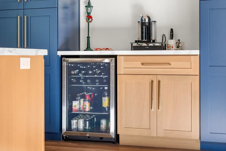 Kitchen beverage station with built-in glass-door wine cooler, natural oak and navy blue shaker cabinets in Thousand Oaks by RnD Builders Inc