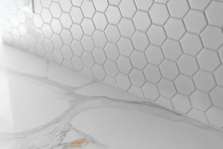 Close-up of white hexagon mosaic tile backsplash above marble-look quartz countertop in Thousand Oaks by RnD Builders Inc