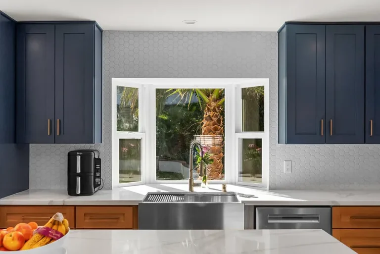 Thousand Oaks home transformation: Modern kitchen with navy shaker cabinets, quartz countertops, and stainless farmhouse sink in Thousand Oaks by RnD Builders Inc