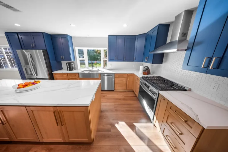 Thousand Oaks home transformation: Two-tone kitchen with navy blue upper cabinets, natural wood lower cabinets, and white quartz countertops in Thousand Oaks by RnD Builders Inc