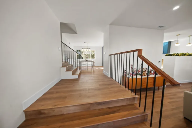 Thousand Oaks home transformation: Split-level interior staircase with wood treads and black iron balusters in Thousand Oaks by RnD Builders Inc