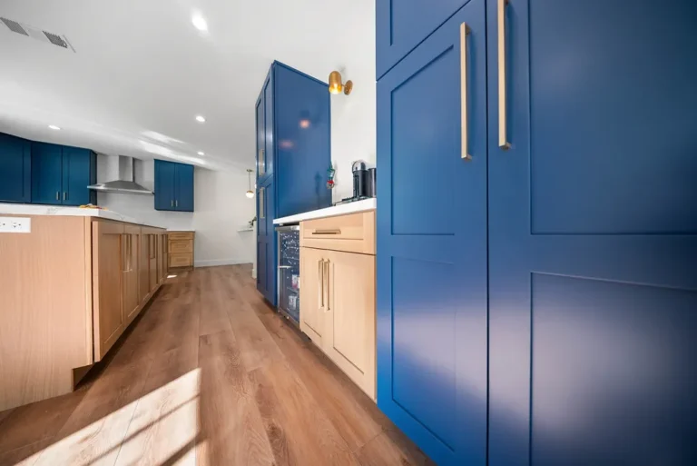 Thousand Oaks home transformation: Two-tone kitchen with navy blue shaker cabinets, natural wood base cabinets, and brass hardware in Thousand Oaks by RnD Builders Inc