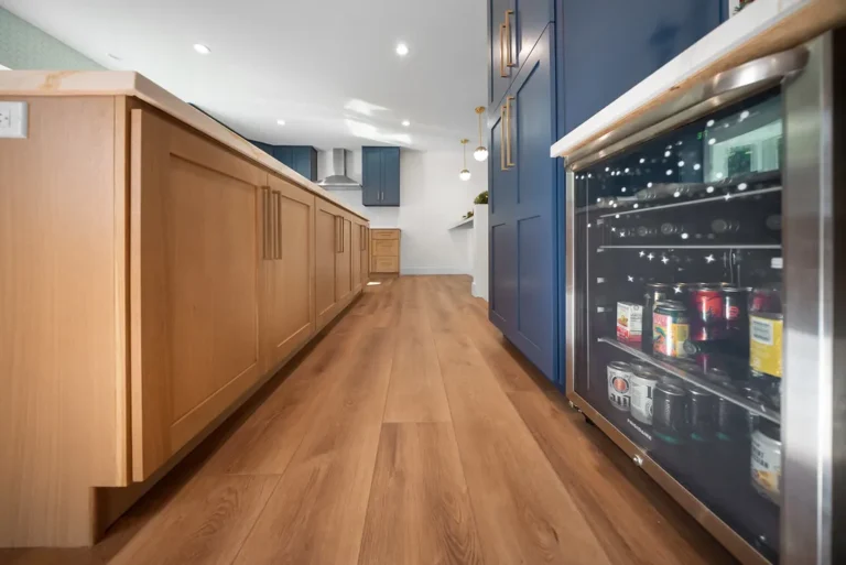 Kitchen with natural wood island, navy blue shaker cabinets, and built-in beverage refrigerator in Thousand Oaks by RnD Builders Inc