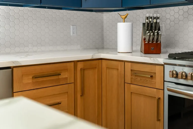 Thousand Oaks home transformation: Natural oak shaker cabinets with brass hardware, white hexagon tile backsplash, and marble countertops in Thousand Oaks by RnD Builders Inc