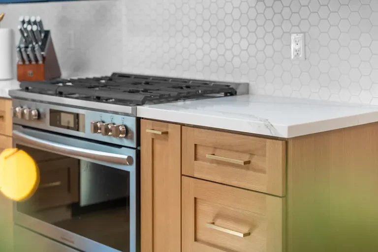 Natural wood shaker cabinets with gold hardware, quartz countertop, and hexagon tile backsplash in Thousand Oaks by RnD Builders Inc