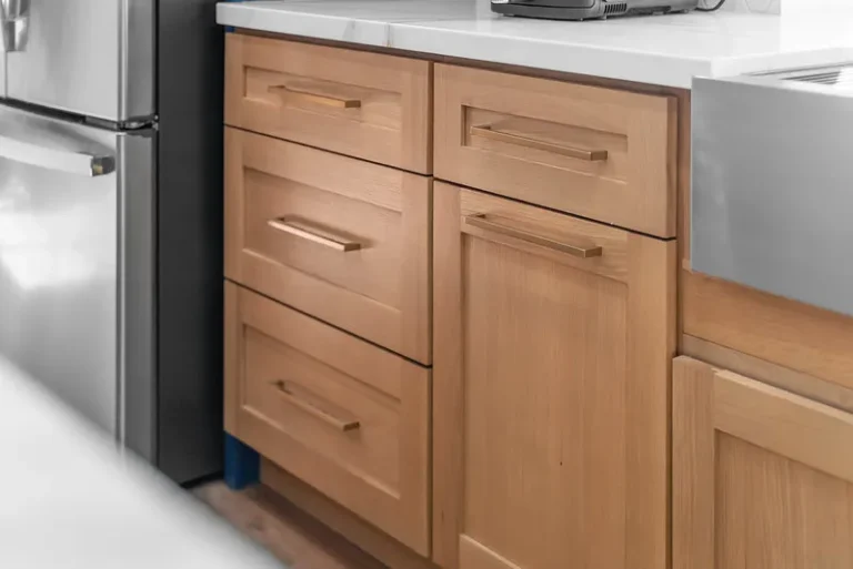 Thousand Oaks home transformation: Natural wood shaker-style kitchen base cabinets with brushed gold bar pulls and white countertop in Thousand Oaks by RnD Builders Inc