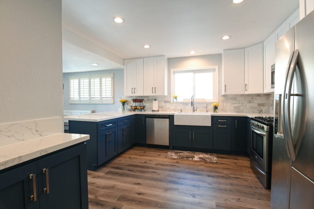 Thousand Oaks navy kitchen: Two-tone kitchen with navy blue lower cabinets, white upper cabinets, farmhouse sink, and stainless steel appliances in Thousand Oaks by RnD Builders Inc