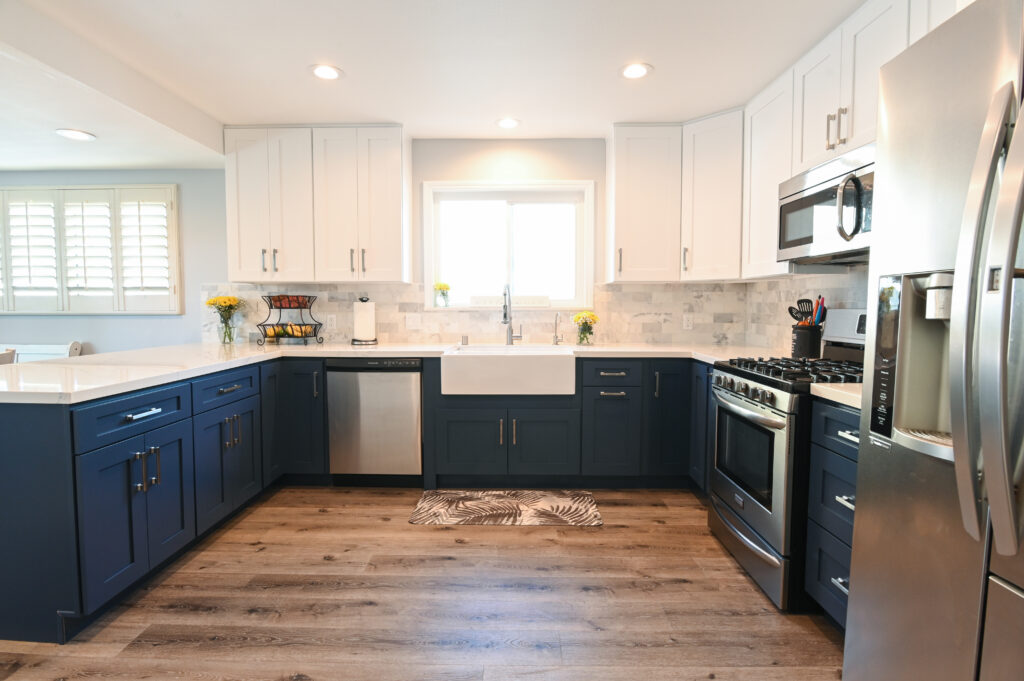 Thousand Oaks navy kitchen: Two-tone kitchen with navy blue lower cabinets, white upper cabinets, farmhouse sink, and stainless steel appliances in Thousand Oaks by RnD Builders Inc