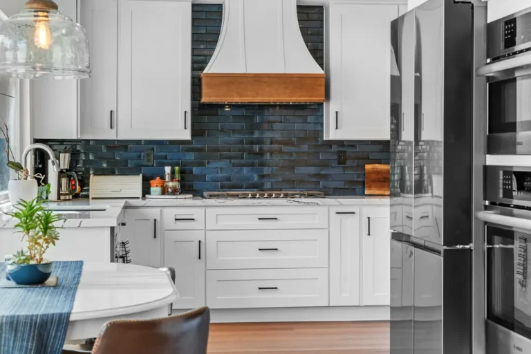 White shaker kitchen with navy subway tile backsplash and copper range hood in Moorpark by RnD Builders Inc