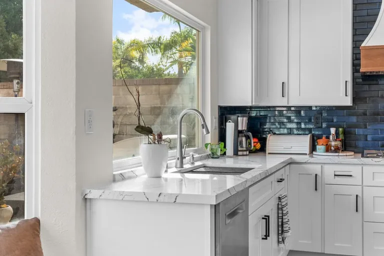 White shaker kitchen with marble countertops, navy subway tile backsplash, and undermount sink in Moorpark by RnD Builders Inc