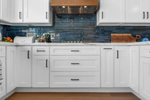 rnd-builders-moorpark-home-remodel-25 White shaker kitchen cabinets with blue subway tile backsplash and wood range hood by RnD Builders Inc