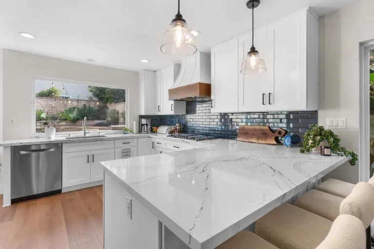 Modern white shaker cabinet kitchen with marble quartz peninsula and dark subway tile backsplash in Moorpark by RnD Builders Inc