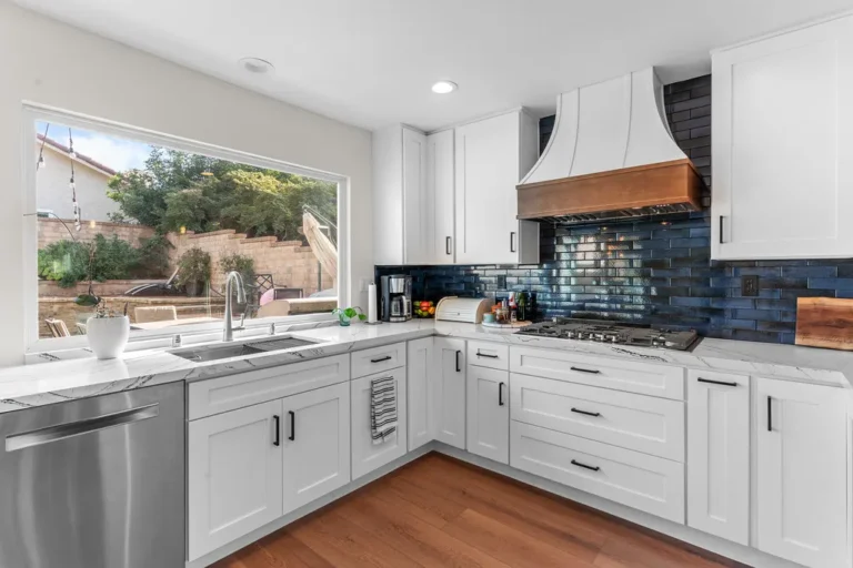 White shaker kitchen with navy subway tile backsplash and copper range hood in Moorpark by RnD Builders Inc