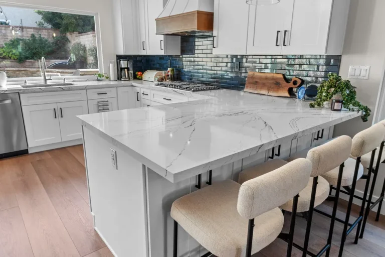 White shaker kitchen with marble quartz island, blue subway tile backsplash, and boucle bar stools in Moorpark by RnD Builders Inc