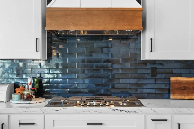 White shaker kitchen with navy blue subway tile backsplash and wood range hood in Moorpark by RnD Builders Inc