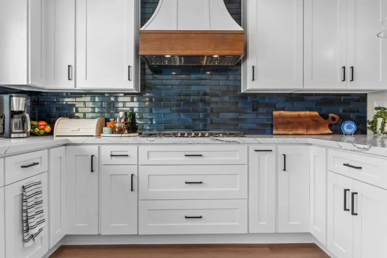 White shaker kitchen with navy blue subway tile backsplash and copper range hood in Moorpark by RnD Builders Inc