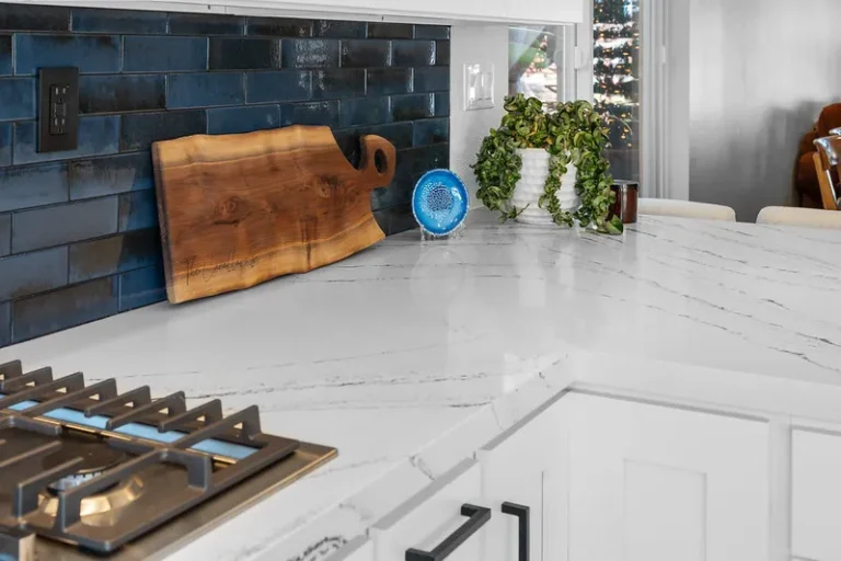 White quartz countertop kitchen with navy blue subway tile backsplash and stainless gas cooktop in Moorpark by RnD Builders Inc