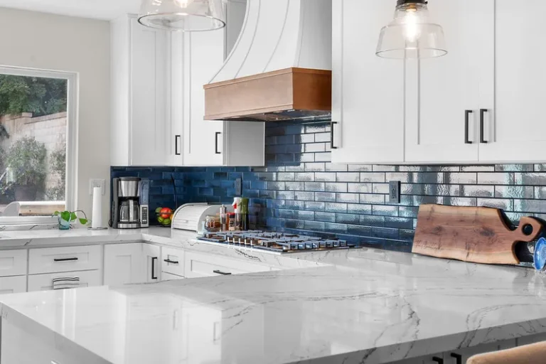 White shaker kitchen with blue subway tile backsplash and copper range hood in Moorpark by RnD Builders Inc