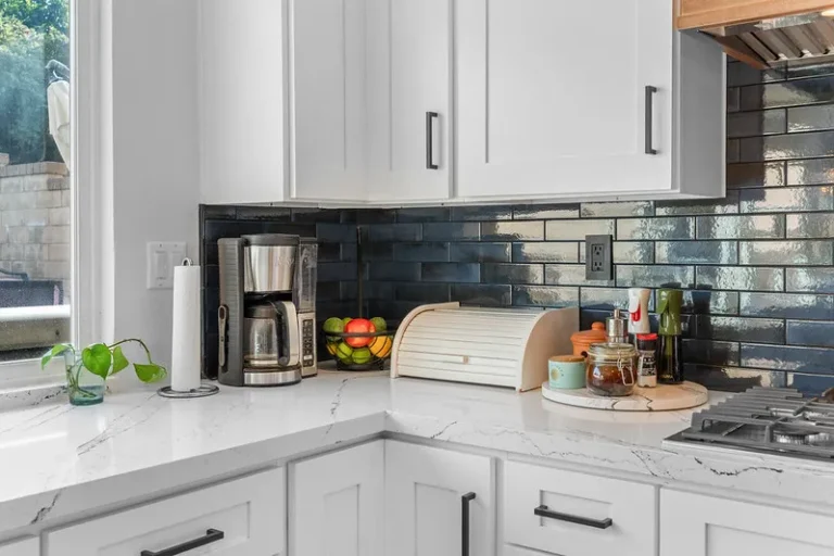 White shaker kitchen cabinets with dark blue subway tile backsplash and white quartz countertops in Moorpark by RnD Builders Inc