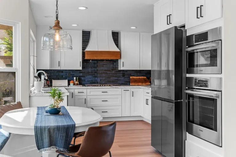 White shaker kitchen with navy zellige tile backsplash, wood-accented range hood, and Bosch appliances in Moorpark by RnD Builders Inc