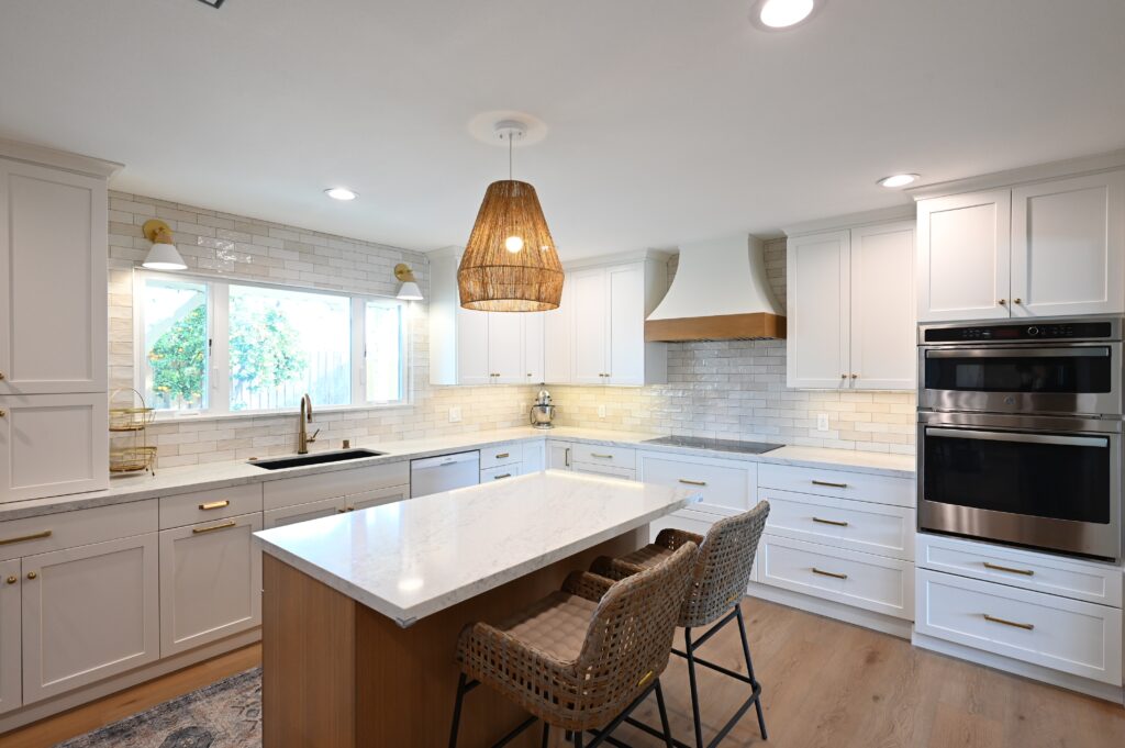 Bright White Shaker Kitchen with Quartz Island in Thousand Oaks Kitchen remodeling in Thousand Oaks with a bright white shaker kitchen, quartz island and woven pendant lights by RnD Builders