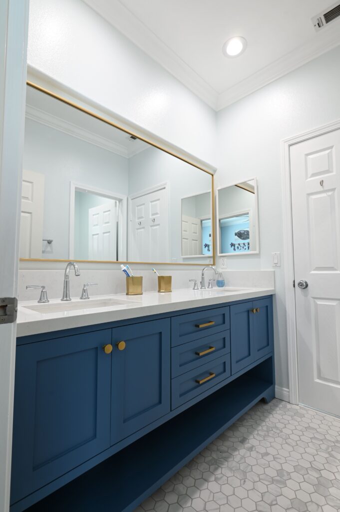 Thousand Oaks Bathroom Remodel Newbury Park bathroom remodel: Double-sink bathroom vanity with navy blue shaker cabinets, white quartz countertop, and gold hardware in Newbury Park by RnD Builders Inc