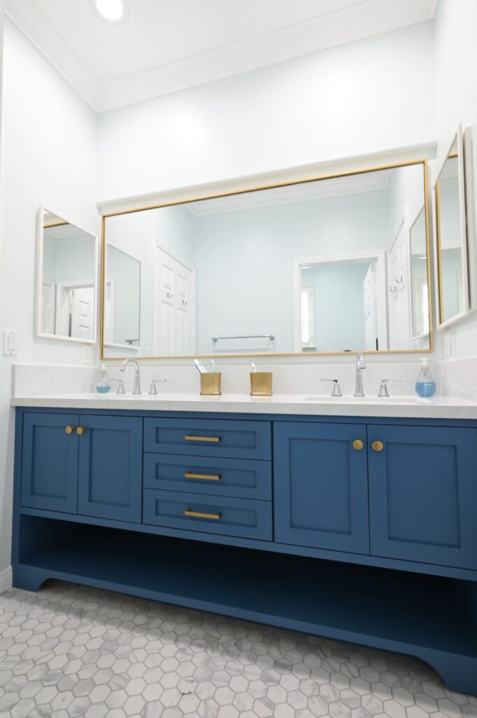 Thousand Oaks Bathroom Remodel Newbury Park bathroom remodel: Double-sink bathroom vanity with navy blue shaker cabinets, gold hardware, and white quartz countertop in Newbury Park by RnD Builders Inc