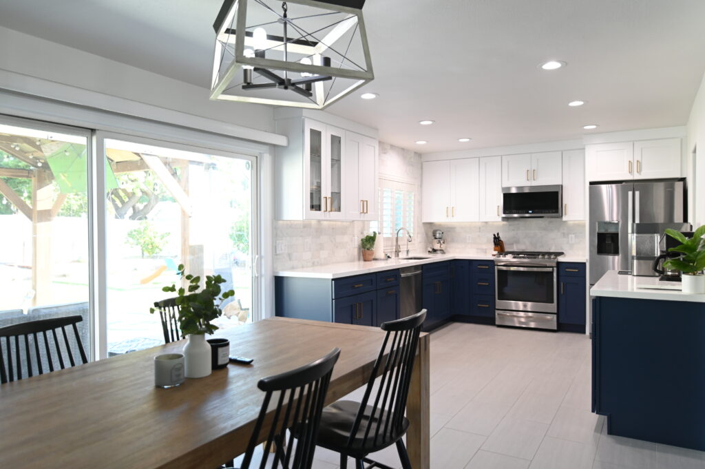 Two-tone kitchen with navy lower cabinets, white upper cabinets, marble backsplash, and stainless steel appliances in Thousand Oaks by RnD Builders Inc