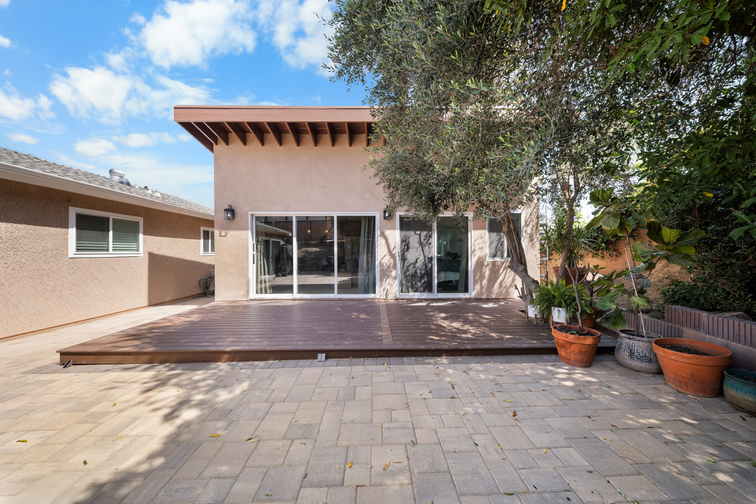 ADU Exterior with Paver Patio and Raised Deck with a stucco exterior, sliding glass doors, a raised deck and a paver patio in Simi Valley by RnD Builders Inc