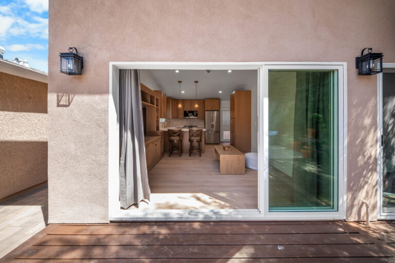 ADU Sliding Door View into Open Living Space with open sliding glass doors, wall lanterns and the interior beyond in Simi Valley by RnD Builders Inc