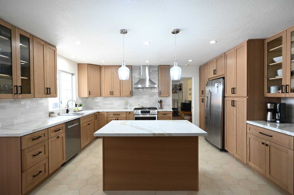 Simi Valley kitchen remodel: Spacious kitchen remodel with warm oak shaker cabinets, quartz island, and hexagon tile flooring in Simi Valley by RnD Builders Inc