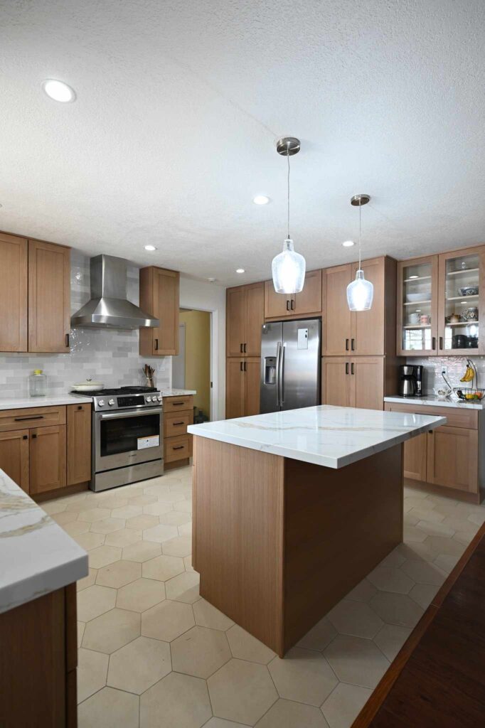 Mid-century modern kitchen remodel with warm wood shaker cabinets, quartz island, and hexagon tile flooring in Simi Valley by RnD Builders Inc