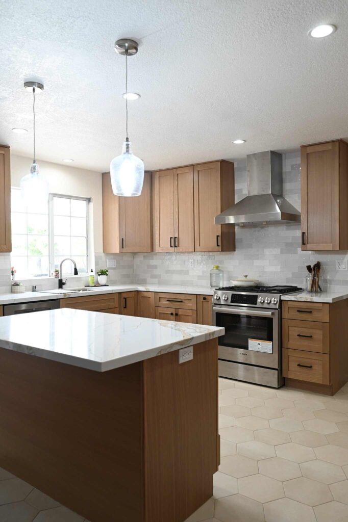 Simi Valley Kitchen Remodel Warm oak shaker kitchen with quartz countertops, stainless range, and center island in Simi Valley by RnD Builders Inc