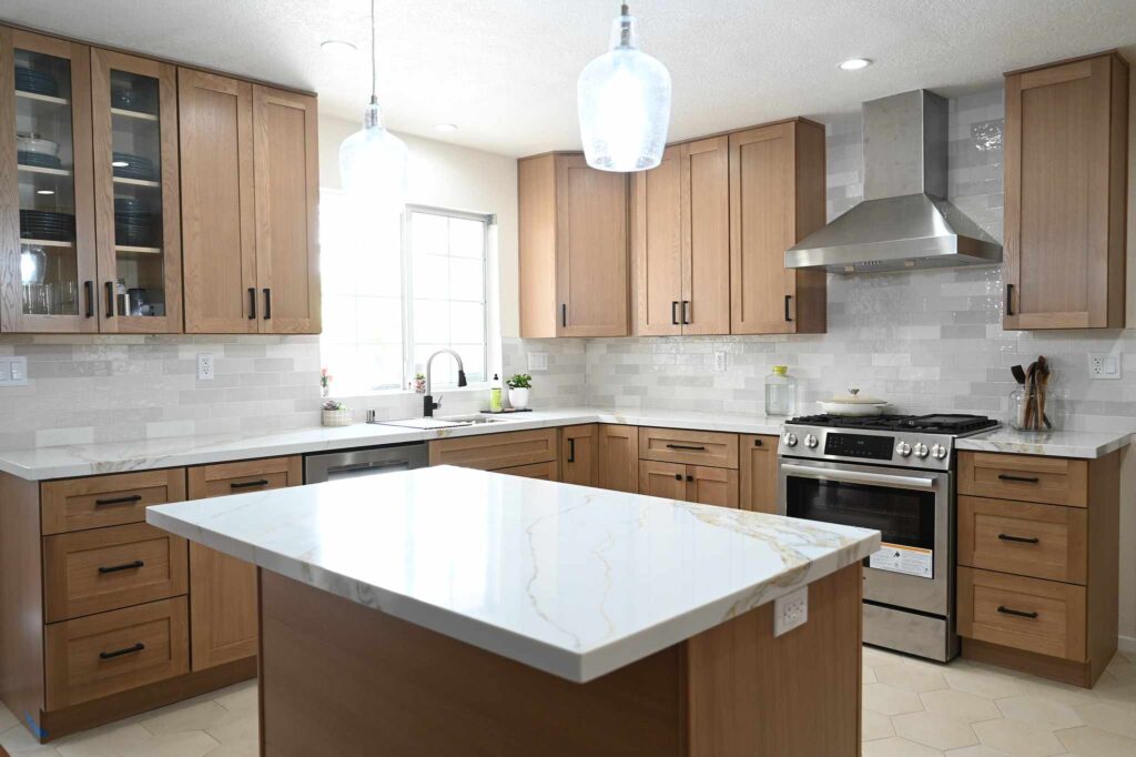 Transitional kitchen remodel with warm oak shaker cabinets, quartz island, and stainless steel range in Simi Valley by RnD Builders Inc