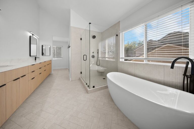 Thousand Oaks bathroom remodel: Modern primary bathroom with freestanding soaking tub, glass shower, and light wood vanity in Thousand Oaks by RnD Builders Inc