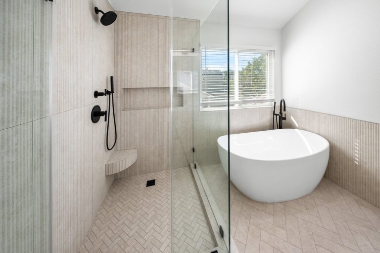 Spa-style master bathroom with freestanding soaking tub, walk-in shower, and matte black fixtures by RnD Builders Inc