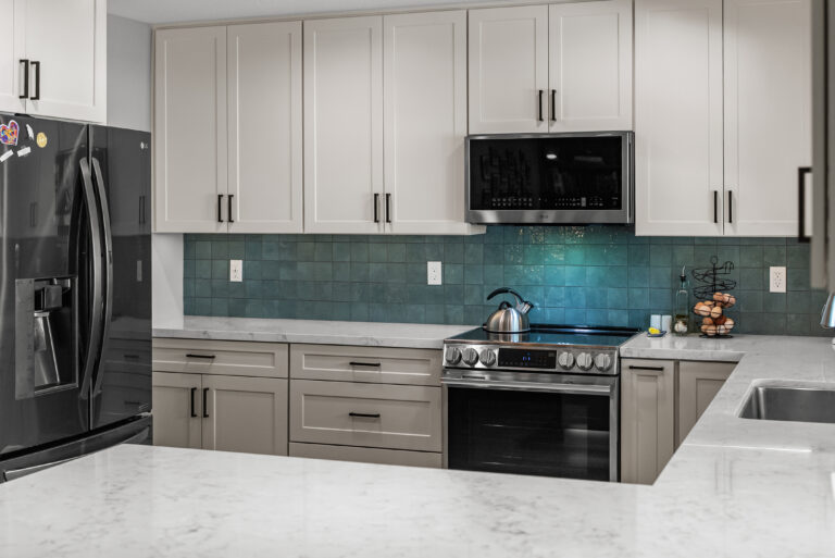 Peninsula Countertop with Teal Backsplash with a white countertop with soft gray veining in Thousand Oaks by RnD Builders Inc
