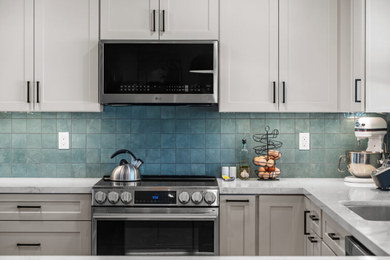 Thousand Oaks kitchen remodel: Stainless Range and Microwave Against Teal Tile in Thousand Oaks by RnD Builders Inc