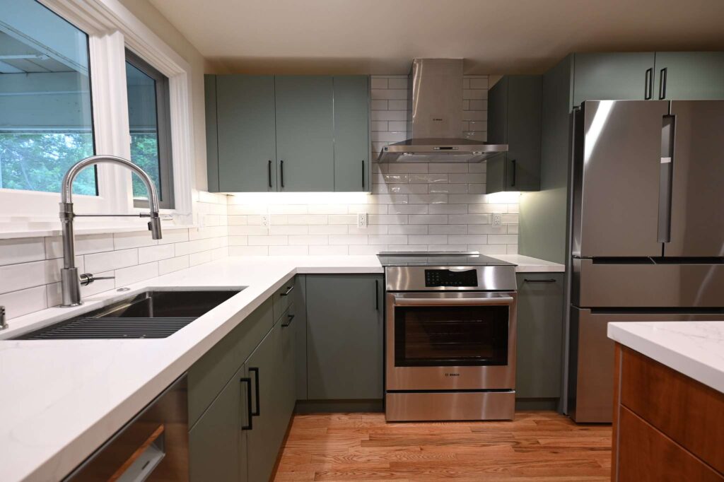 Thousand Oaks green kitchen: Modern kitchen with sage green flat-front cabinets, white quartz countertops, and stainless steel Bosch appliances in Thousand Oaks by RnD Builders Inc