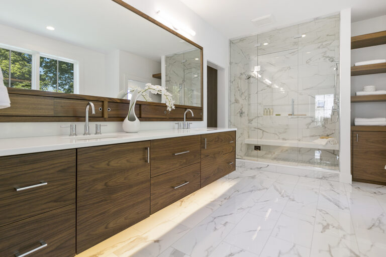 A modern bathroom featuring elegant marble countertops and stylish wood cabinets, showcasing a blend of luxury and warmth.